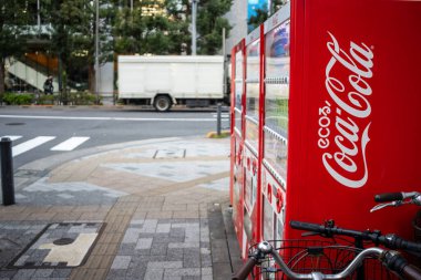 Tokyo, Japonya, 30 Ekim 2023: Tokyo caddesinde bir bisikletin yanında Coca-Cola satış makineleri