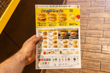 Tokyo, Japonya, 30 Ekim 2023: Tokyo 'da müşteri fast food menüsü tutuyor