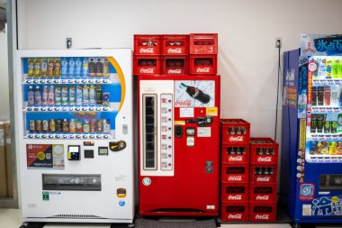 Tokyo, Japonya, 30 Ekim 2023: Asahi içecek makinesinin yanındaki kırmızı Coca-Cola satış makineleri