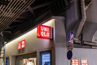 Tokyo, Japonya, 30 Ekim 2023: UNIQLO mağazasının dışı gece aydınlık tabelalarla dolu