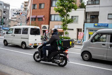 Tokyo, Japonya, 31 Ekim 2023: Şehir Trafiğinde Scooter Süren Teslimat Kişi