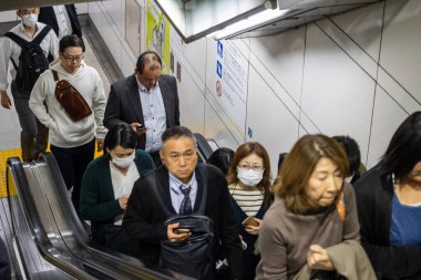 Tokyo, Japonya, 31 Ekim 2023: Tokyo metro istasyonunda yürüyen merdivenden inen insanlar