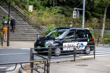 Tokyo, Japonya, 31 Ekim 2023: Yoyogi Parkı yakınlarındaki yaya geçidinden geçen taksi