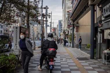 Tokyo, Japonya, 31 Ekim 2023: Tokyo sokaklarında yaya ve motosikletçi