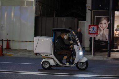 Tokyo, Japonya, 31 Ekim 2023: Elektrik dağıtım scooter 'ı gece sokakta
