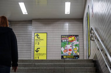 Tokyo, Japonya, 31 Ekim 2023: Bir Tokyo metro istasyonunda yaya tabelalarının önünden geçiyor