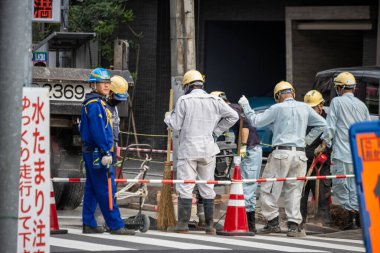 Tokyo, Japonya, 31 Ekim 2023: İnşaat işçileri kentte güvenlik bariyerleri olan bir bölgede