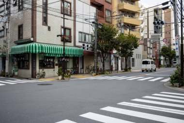Tokyo, Japonya, 31 Ekim 2023: Zebra geçidi ve apartmanları olan bir yerleşim bölgesinde sessiz kavşak