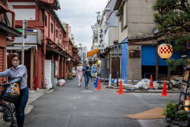 Tokyo, Japonya, 31 Ekim 2023: Geleneksel dükkanlar ve temizlik yapan bir kişi