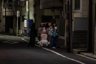 Tokyo, Japonya, 31 Ekim 2023: Bir gece Tokyo caddesinde fotoğraf için poz veren bir grup arkadaş