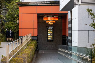 Tokyo, Japonya, 1 Kasım 2023: Geleneksel fenerler ve öğrencilerin geçtiği modern bina girişi