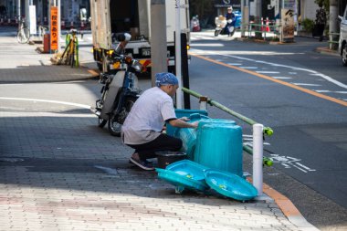 Tokyo, Japonya, 1 Kasım 2023: Kaldırımda scooter tamir eden işçi