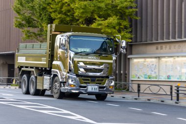 Tokyo, Japonya, 1 Kasım 2023: Isuzu kamyonu modern binalarla şehir caddesinde sürüyor