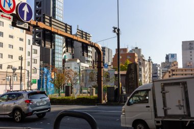Tokyo, Japonya, 1 Kasım 2023: Arka planda modern mimari olan bir şehir üst geçidi yakınında trafik