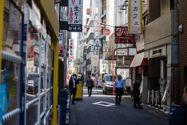 Tokyo, Japonya, 1 Kasım 2023: Yayalar ve tabelalarla dolu dar bir cadde