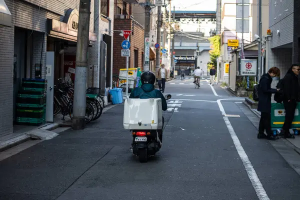 Tokyo, Japonya, 1 Kasım 2023: Alleyway 'de Scooter' da Teslimat Kişi