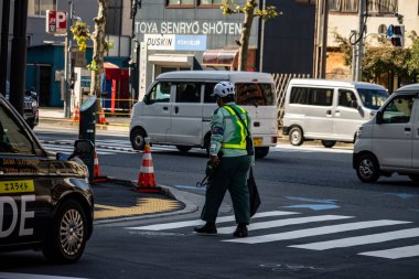 Tokyo, Japonya, 1 Kasım 2023: Yoğun bir kavşağı yöneten trafik denetçisi