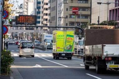 Tokyo, Japonya, 1 Kasım 2023: Canlı yeşil teslimat kamyonu Cool Green reklamı ile şehir caddesinde