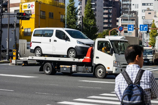 Tokyo, Japonya, 1 Kasım 2023: Beyaz bir minibüs taşıyan çekici