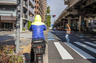 Tokyo, Japonya, 2 Kasım 2023: Şehir yaya geçidinde inşaat işçisi ve yaya