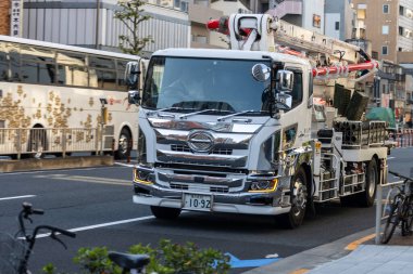 Tokyo, Japonya, 2 Kasım 2023: Şehir yolunda merdiveni olan inşaat aracı