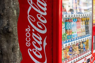 Tokyo, Japonya, 2 Kasım 2023: Gachapon oyuncak kapsül otomat otomatının yanındaki Coca-Cola otomatının yakın çekimi