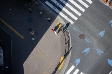 Tokyo, Japonya, 2 Kasım 2023: Yaya geçidinin insanlarla ve yön oklarıyla hava görüntüsü