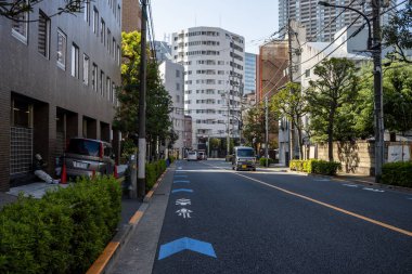 Tokyo, Japonya, 2 Kasım 2023: Park halindeki arabaları ve çevresindeki binaları olan sakin bir sokak