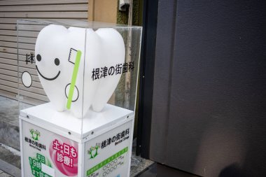 Tokyo, Japonya, 2 Kasım 2023: Bir şehir caddesinde dişçi hizmetleri için reklam maskotu
