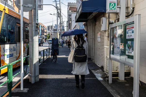 Tokyo, Japonya, 2 Kasım 2023: İnsanlar Shibuya İstasyonu yakınlarında yağmurlu bir günde şemsiye altında yürüyorlar