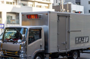 Tokyo, Japonya, 2 Kasım 2023: Japon metin işaretiyle şehir caddesinde teslimat kamyonu