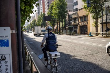Tokyo, Japonya, 2 Kasım 2023: Japon Polis Memuru Bisikletle Sokakta Devriye geziyor