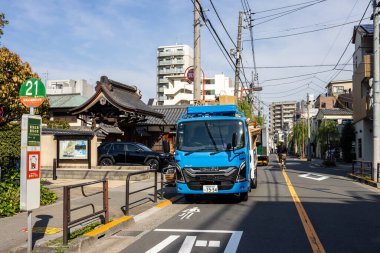 Tokyo, Japonya, 2 Kasım 2023: Arka planda geleneksel mimari ile Tokyo 'da bir sokakta mavi teslimat kamyonu