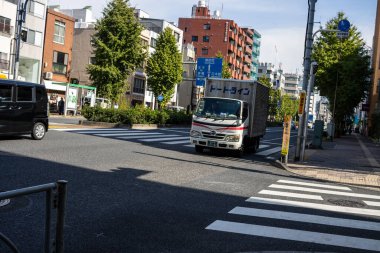 Tokyo, Japonya, 2 Kasım 2023: Teslimat kamyonları ve yaya geçişleriyle şehir sokak sahnesi