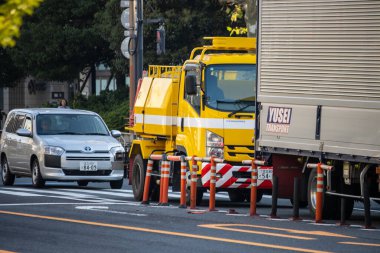Tokyo, Japonya, 2 Kasım 2023: Sarı vinç ve güvenlik bariyerleriyle yol yapımı