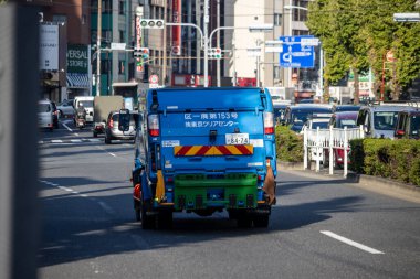 Tokyo, Japonya, 2 Kasım 2023: Yoğun bir Tokyo caddesinde çalışan çöp kamyonu