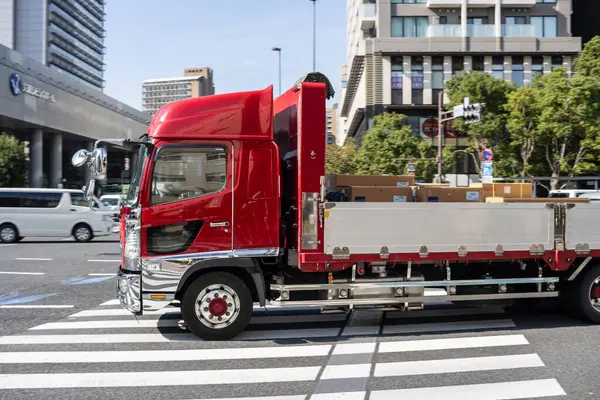 Tokyo, Japonya, 2 Kasım 2023: Kırmızı teslimat kamyonu şehir caddesinde hareket halinde