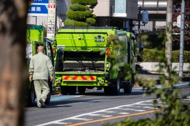 Tokyo, Japonya, 3 Kasım 2023: Şehir caddesinde işçilerle birlikte çalışan çöp kamyonu