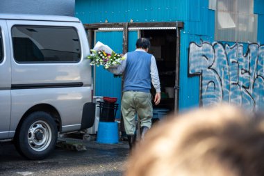 Tokyo, Japonya, 3 Kasım 2023: Çiçekleri Mavi Bina 'da Bir Minibüse Yükleyen Adam