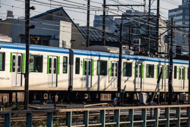 Tokyo, Japonya, 3 Kasım 2023: Arka planda Şehir Binaları ile JR Yamanote Hattı 'ndan geçen tren