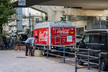 Tokyo, Japonya, 4 Kasım 2023: Yoğun bir caddeye Coca-Cola taşıyan kişi
