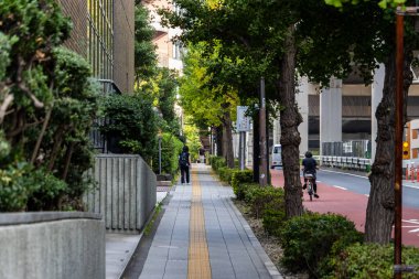 Tokyo, Japonya, 4 Kasım 2023: Kaldırımda Bisikletçi ve Yayalarla Barışçıl Tokyo Sokak Sahnesi