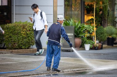 Tokyo, Japonya, 4 Kasım 2023: Fabrikanın Önündeki Kaldırımı Temizleyen İşçi