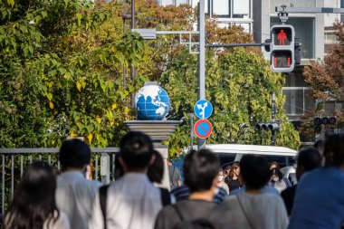 Tokyo, Japonya, 4 Kasım 2023: Dünya Küre Heykeli ve Şehir Trafik Işıklarıyla Kalabalık Yayalar Geçidi