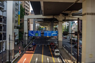 Tokyo, Japonya, 4 Kasım 2023: Dynamic Street View Under the Overpass with Directional Road Marings and Traraffic