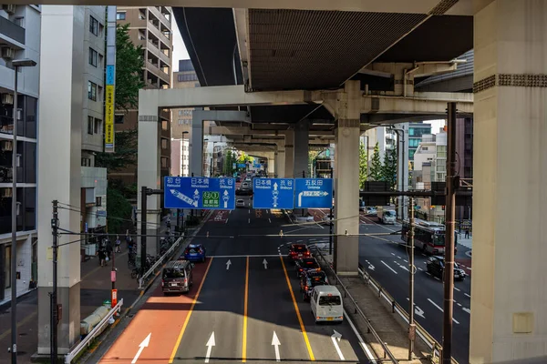 Tokyo, Japonya, 4 Kasım 2023: Dynamic Street View Under the Overpass with Directional Road Marings and Traraffic