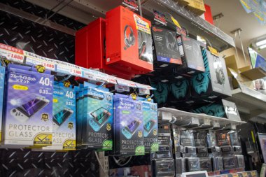 Tokyo, Japonya, 4 Kasım 2023: Çeşitli teknolojik aksesuarlarla elektronik mağazası rafı