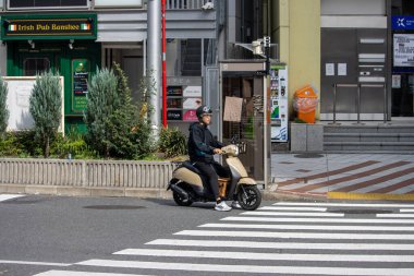 Tokyo, Japonya, 4 Kasım 2023: İrlanda Pub 'ından Scooter Geçen Teslimat Kişi