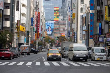 Tokyo, Japonya, 4 Kasım 2023: Reklam panoları ve Trafik İlanlı Şehir Sokak Sahnesi