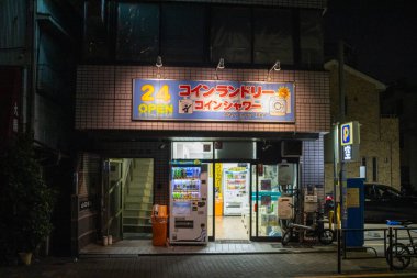 Tokyo, Japonya, 4 Kasım 2023: Parlak tabelalı bir Japon çamaşırhanesinin gece manzarası